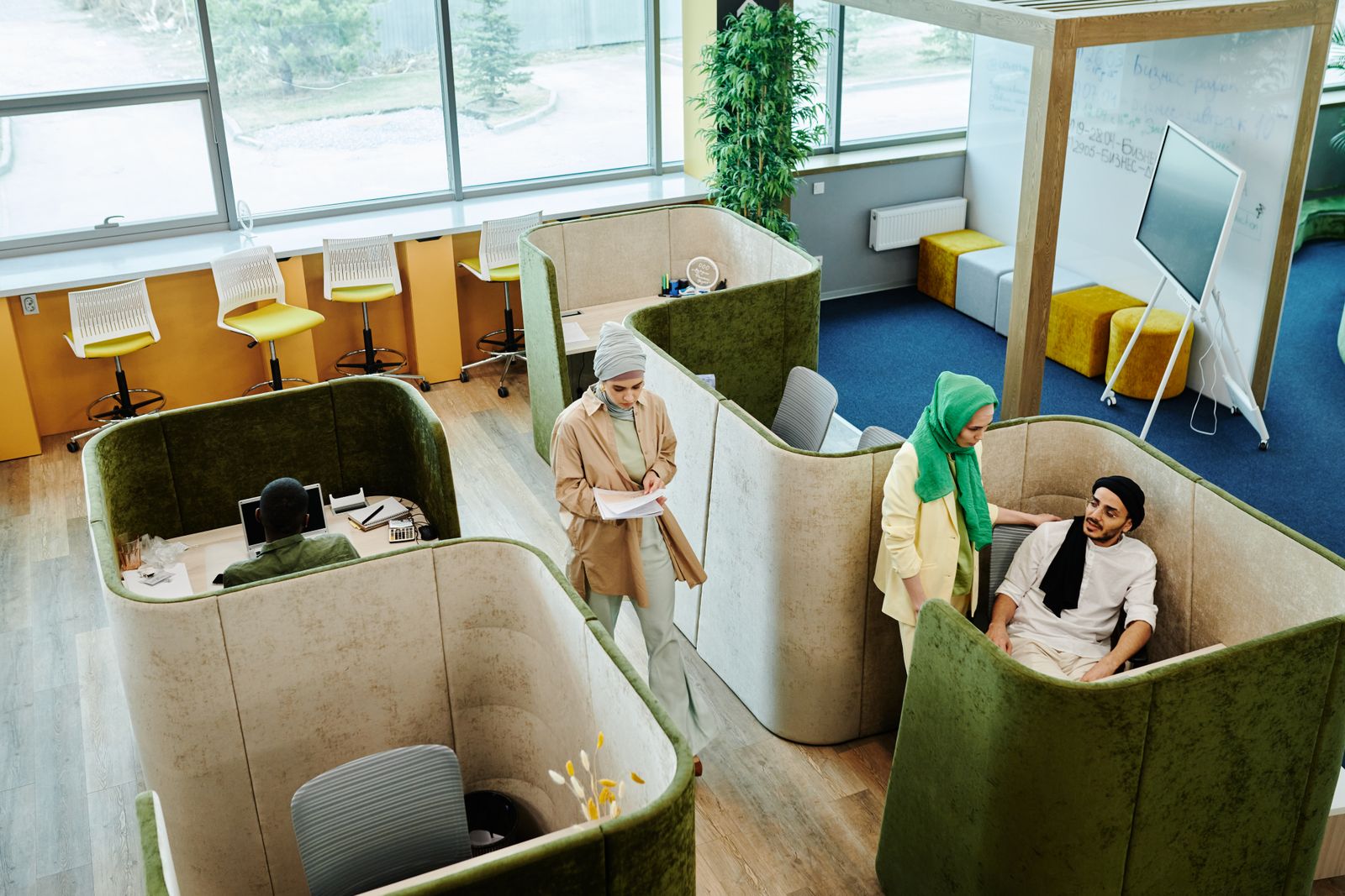 شخص يتنقّل بين عدّة محطات عمل مختلفة مرتّبة جنباً إلى جنب في مساحة عمل مضاءة طبيعياً، كل محطة بأدوات مختلفة عن التي تليها
