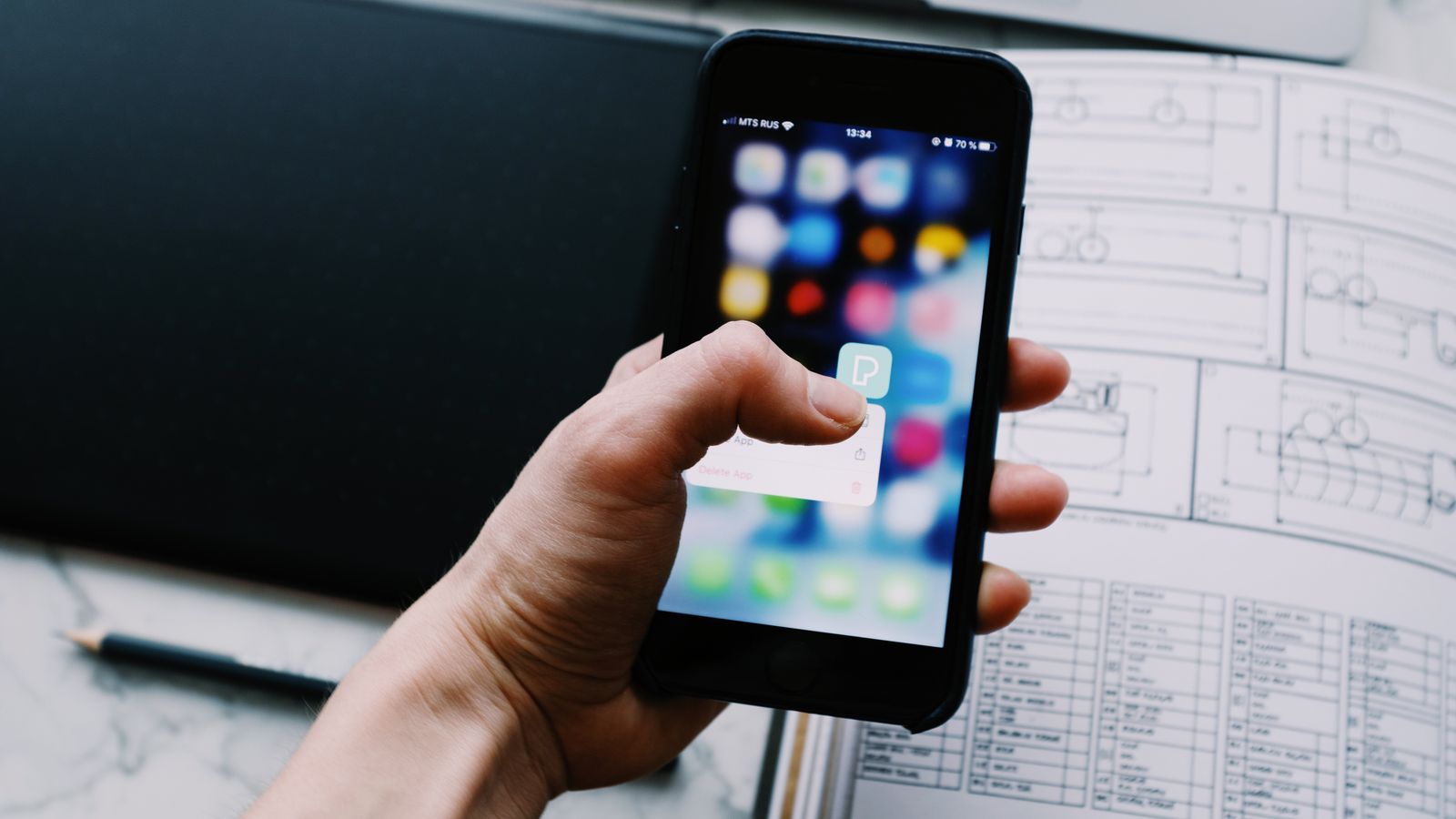 Hands holding a phone and typing a name into a search bar in a calm office setting